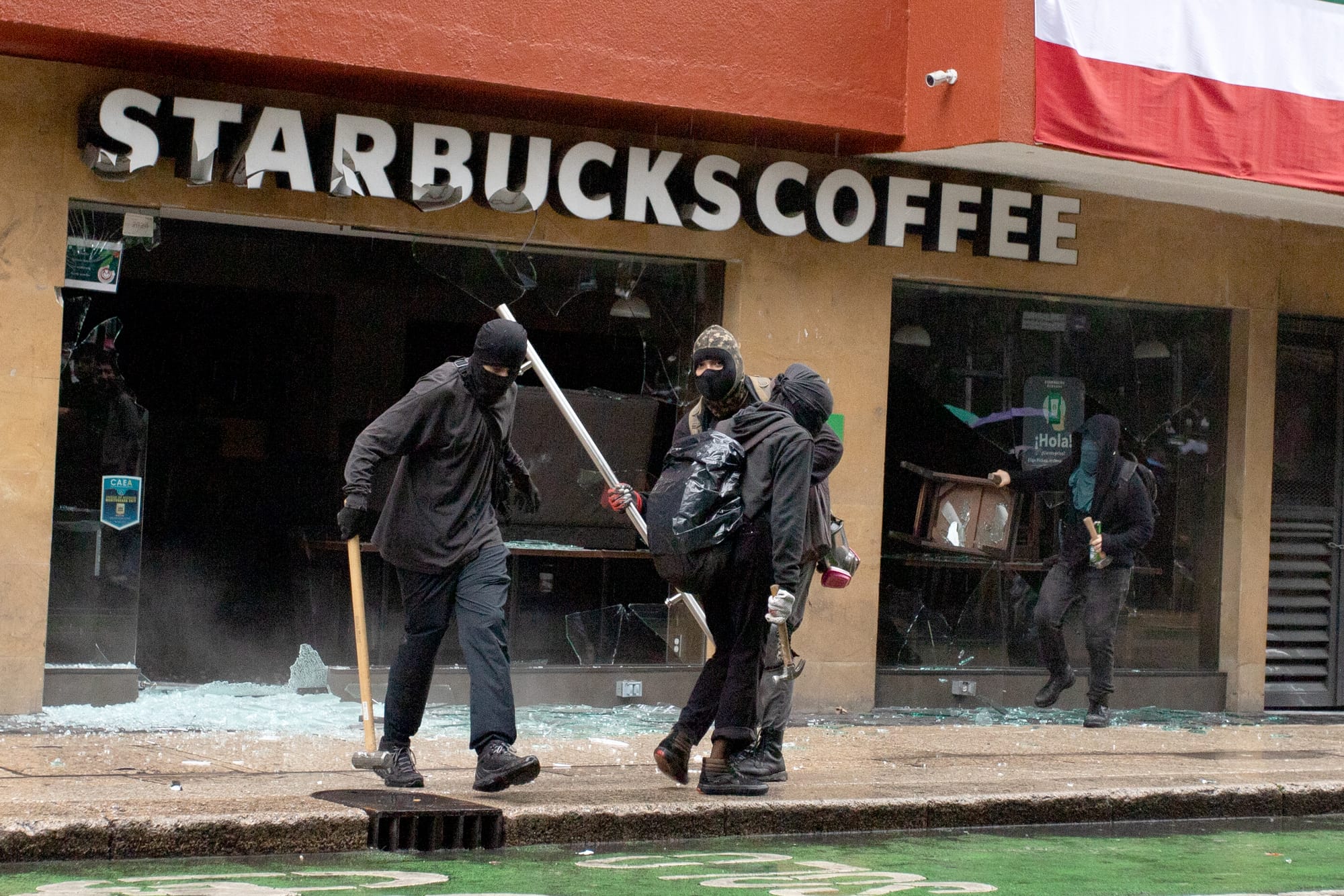 Demonstrators smashing the windows of Starbucks coffee shops. (Photo: Václav Lang)