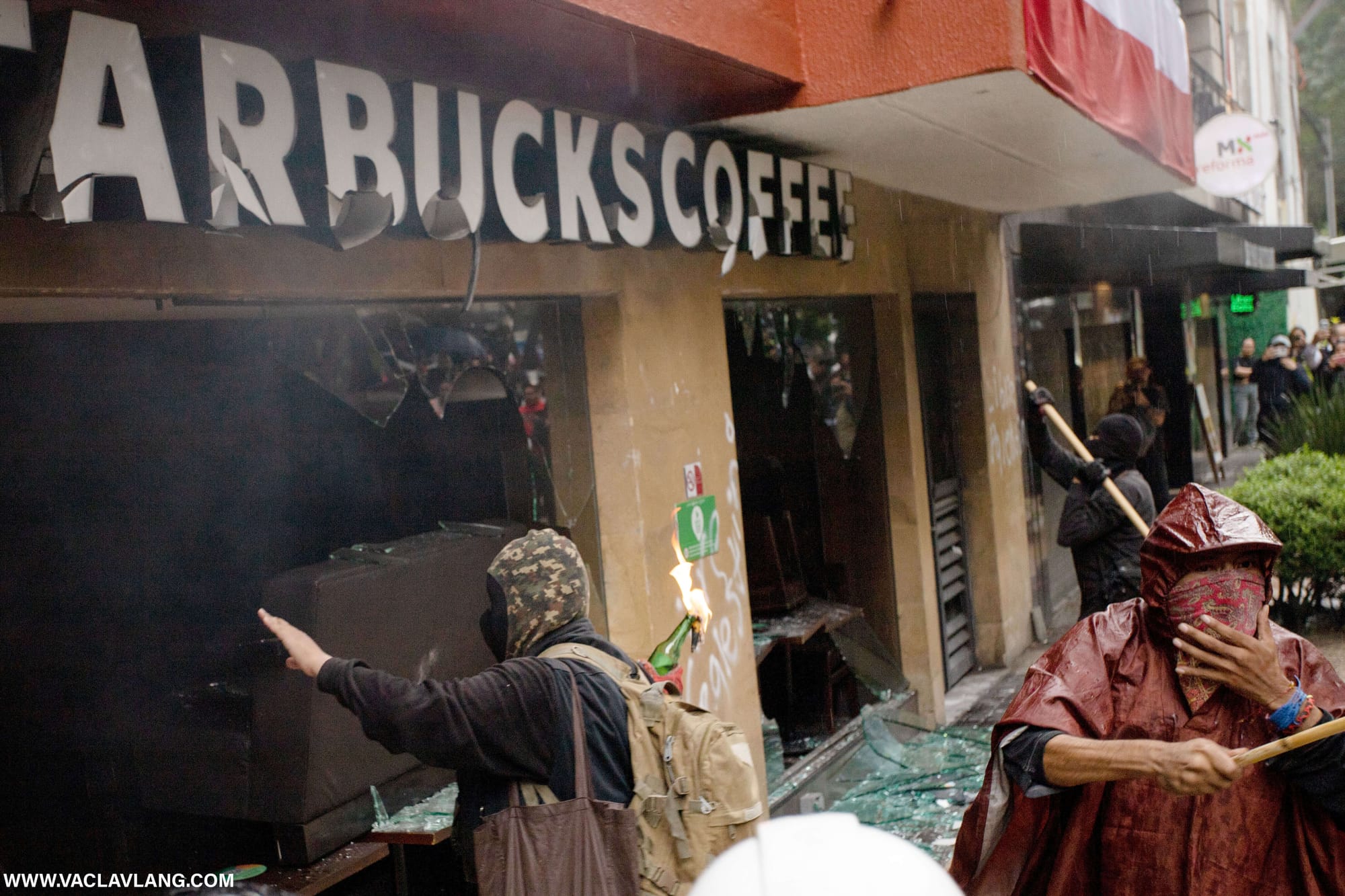 Demonstrating with a Molotov cocktail outside a Starbucks. (Photo: Václav Lang)